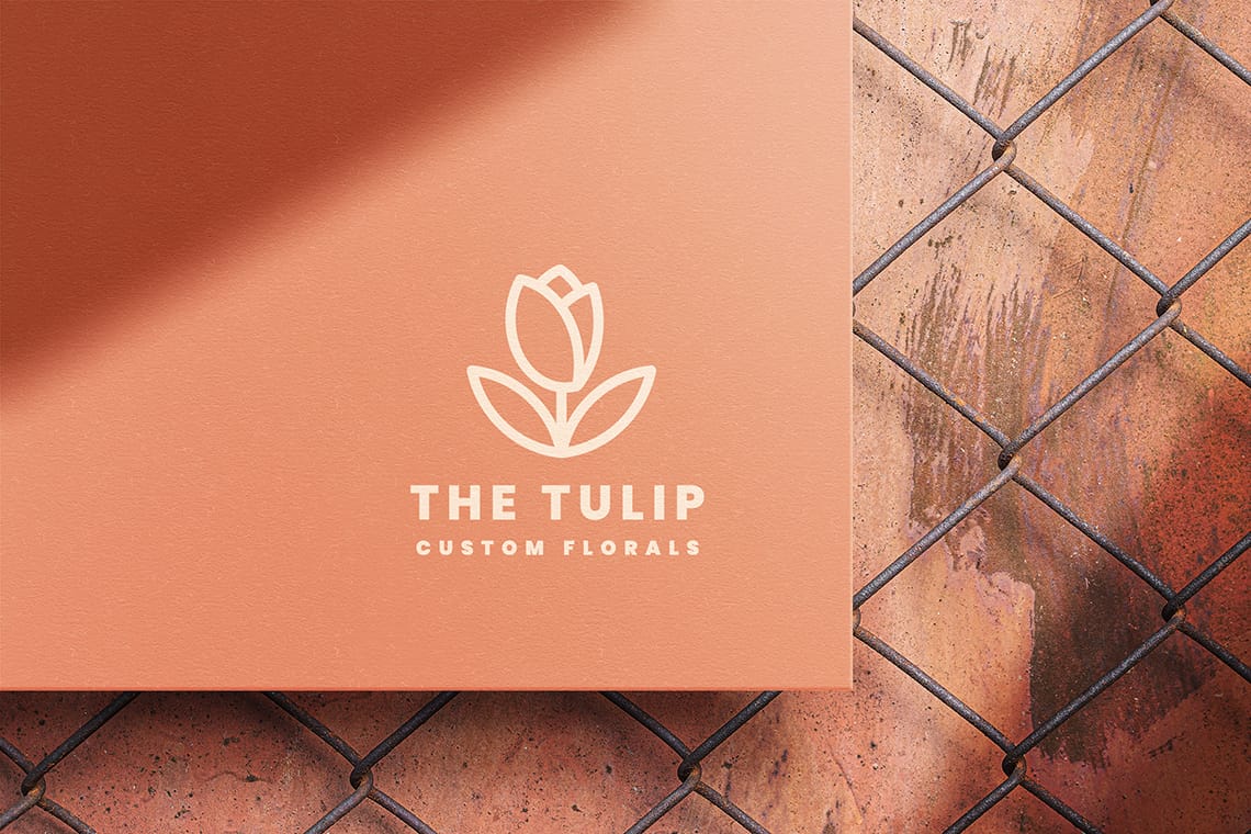 Photoshop The Tulip Paper Logo Mockup on Grid Fence