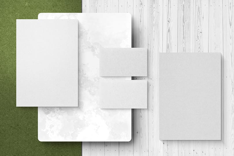 Image Letter Paper and Business Card Mockup On White Wood and Grassy Field Texture